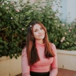 woman sitting near pink flowers at daytime